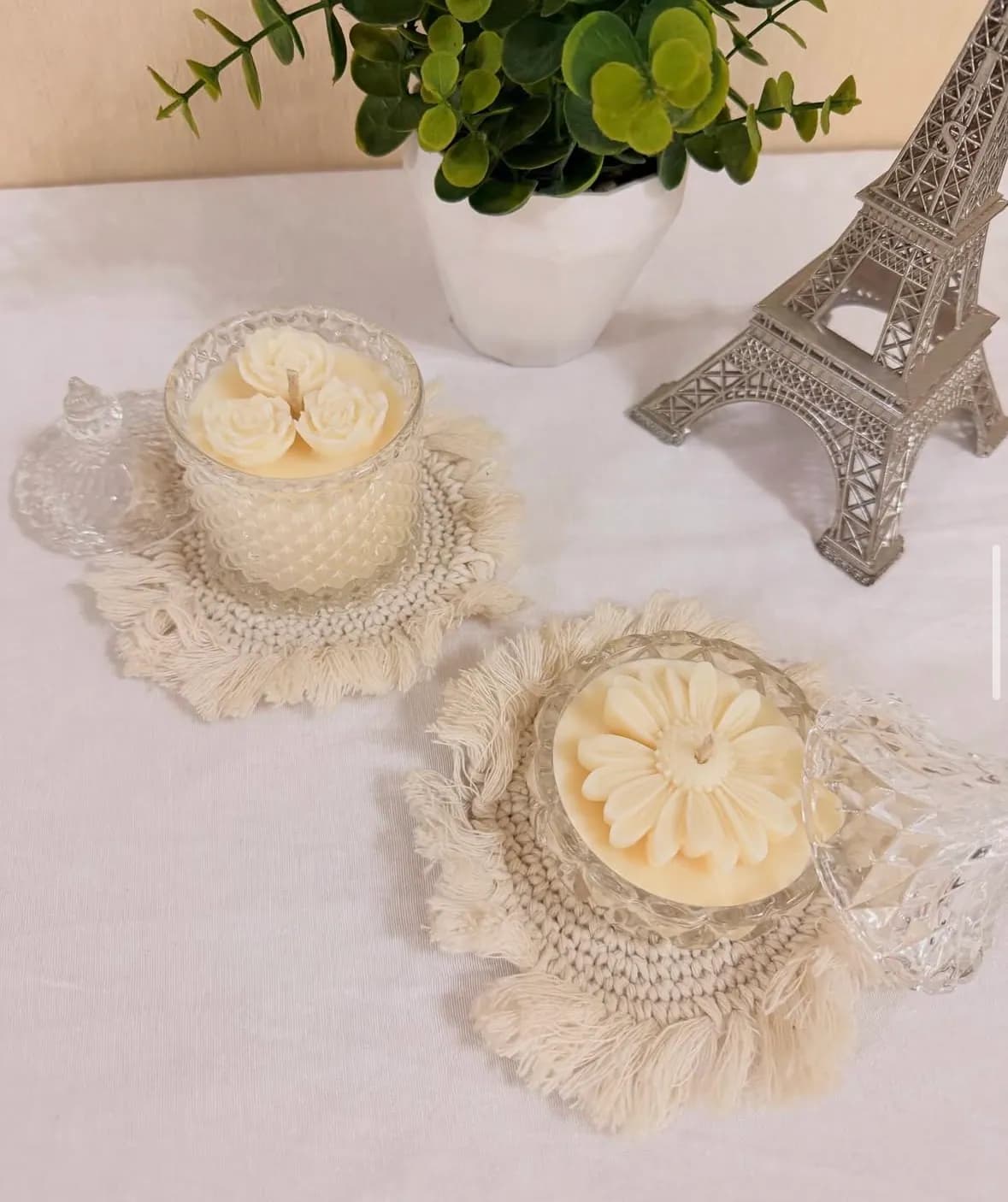 Velas decorativas con forma de flor sobre posavasos de macramé